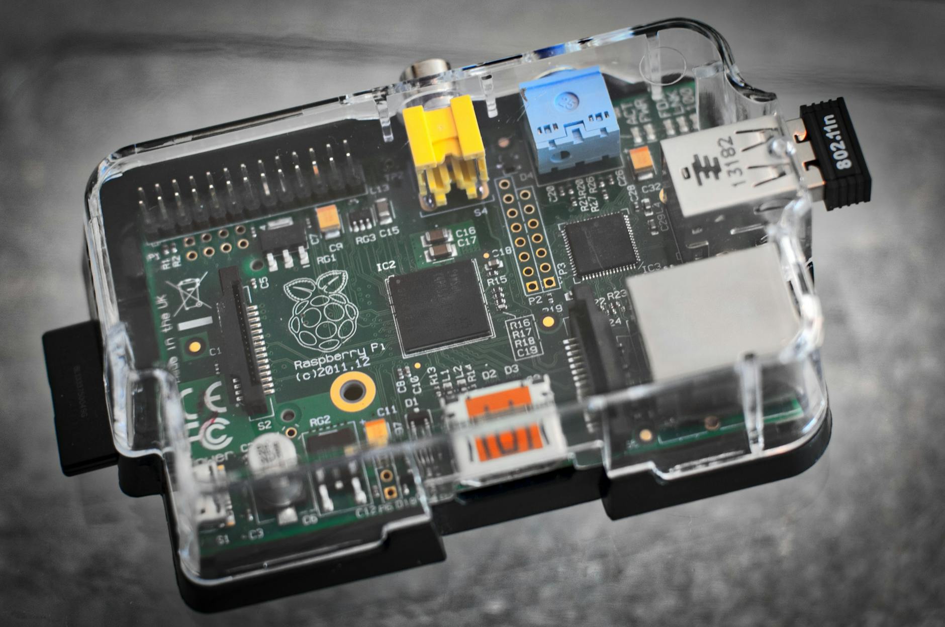 Płytka Raspberry Pi w przezroczystej obudowie, zbliżenie na elektronikę