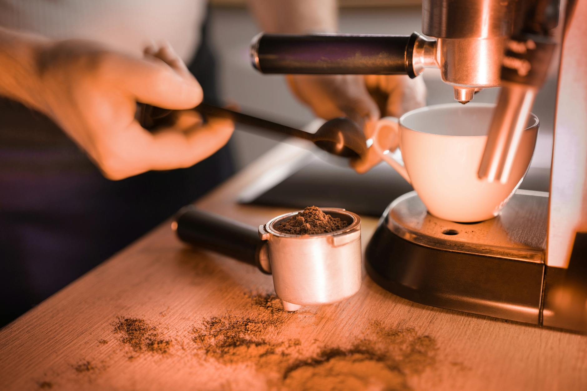 Barista przygotowuje espresso z świeżo mielonej kawy w ekspresie