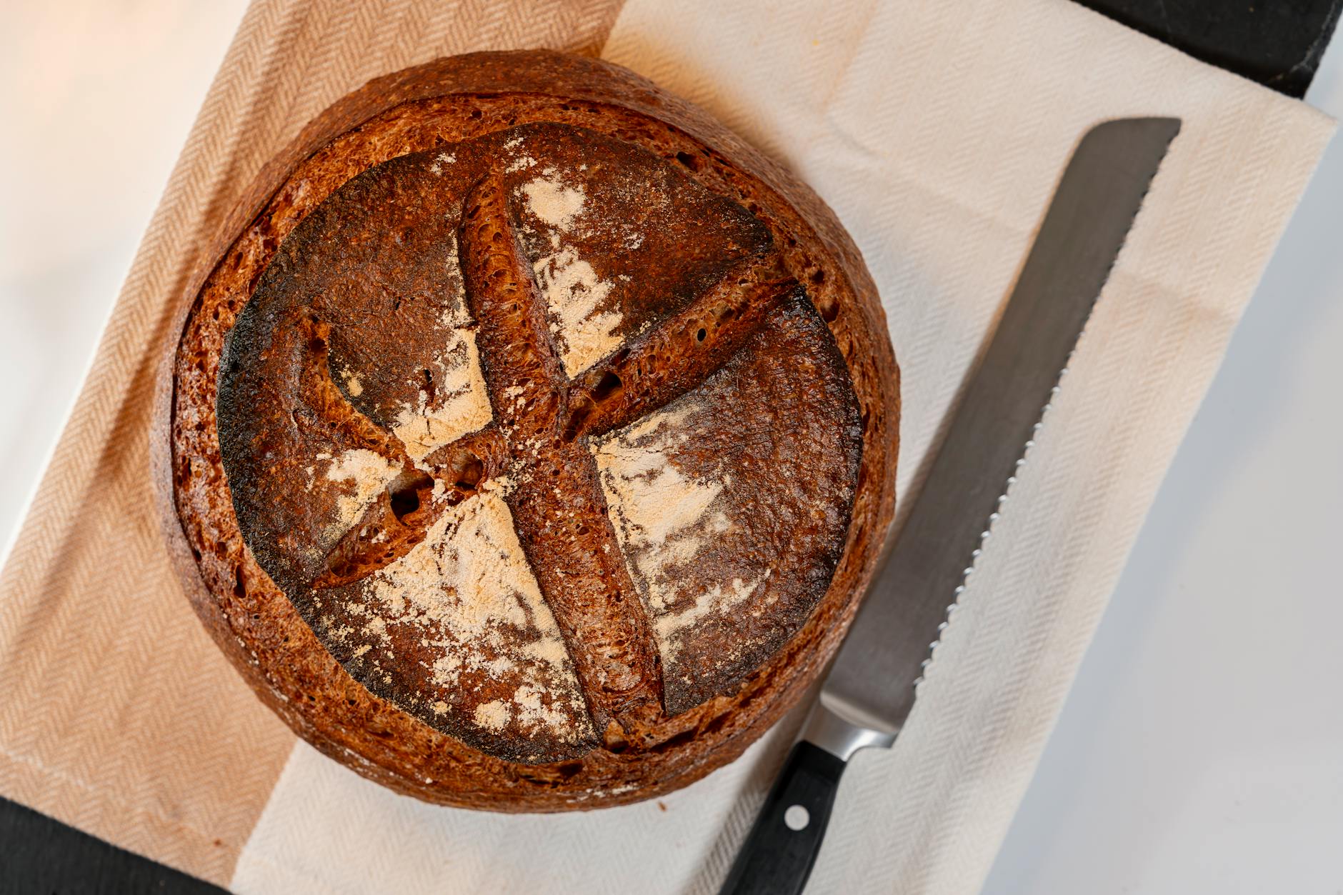 Bochenek domowego chleba na zakwasie na ściereczce z nożem