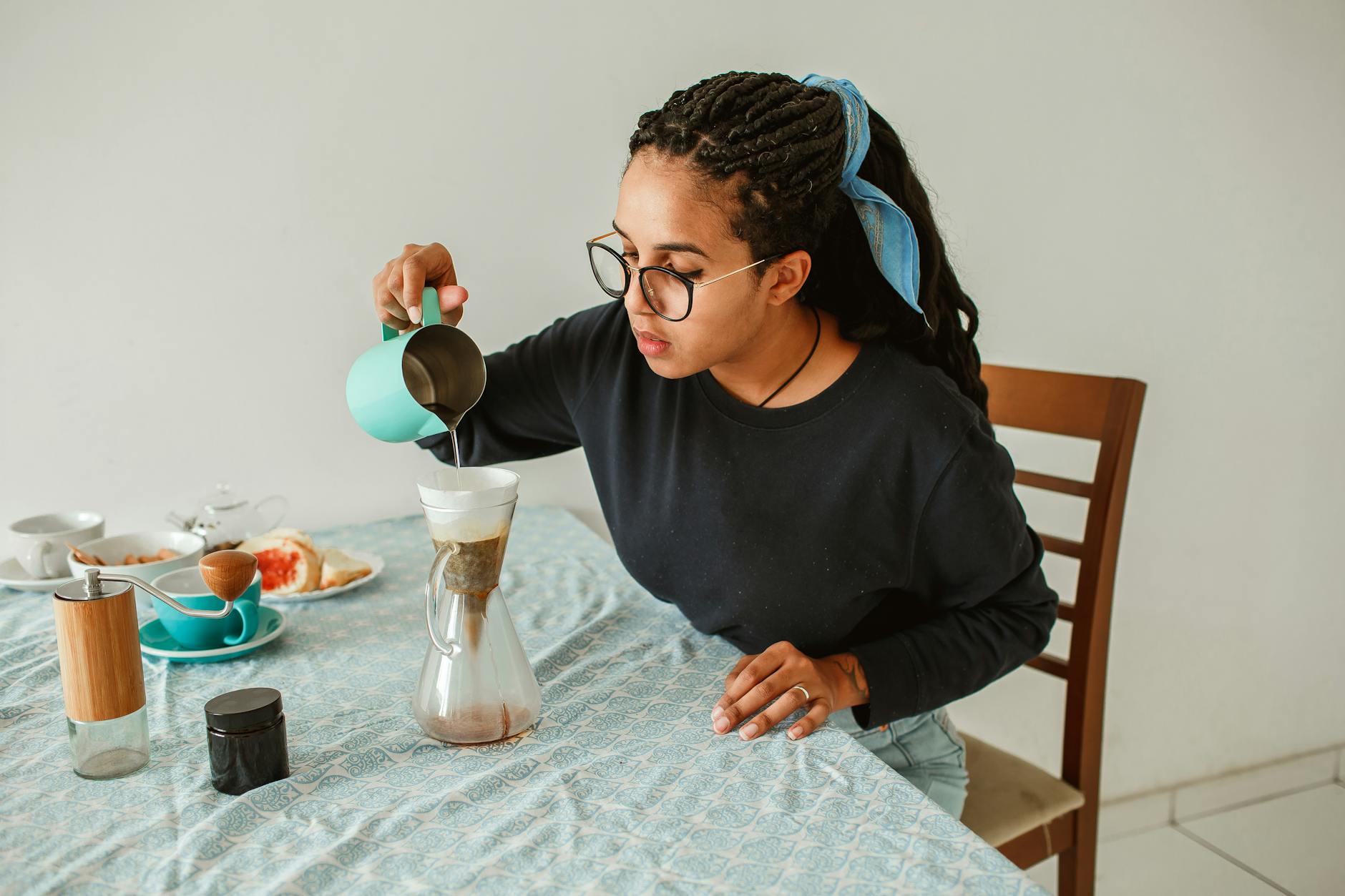 Kobieta przygotowuje kawę przelewową w przytulnej domowej kuchni