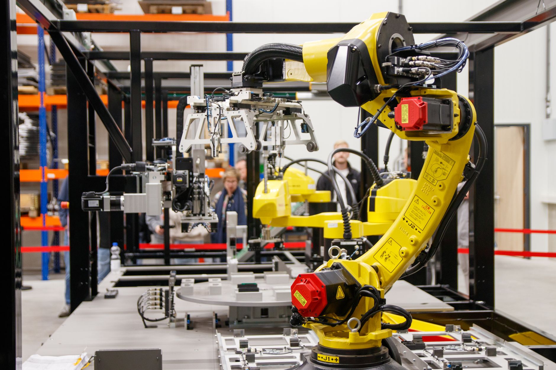 Żółte ramię robota przemysłowego przy pracy w nowoczesnej fabryce